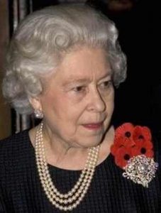 queen elizabeth II wearing a triple strand pearl necklace